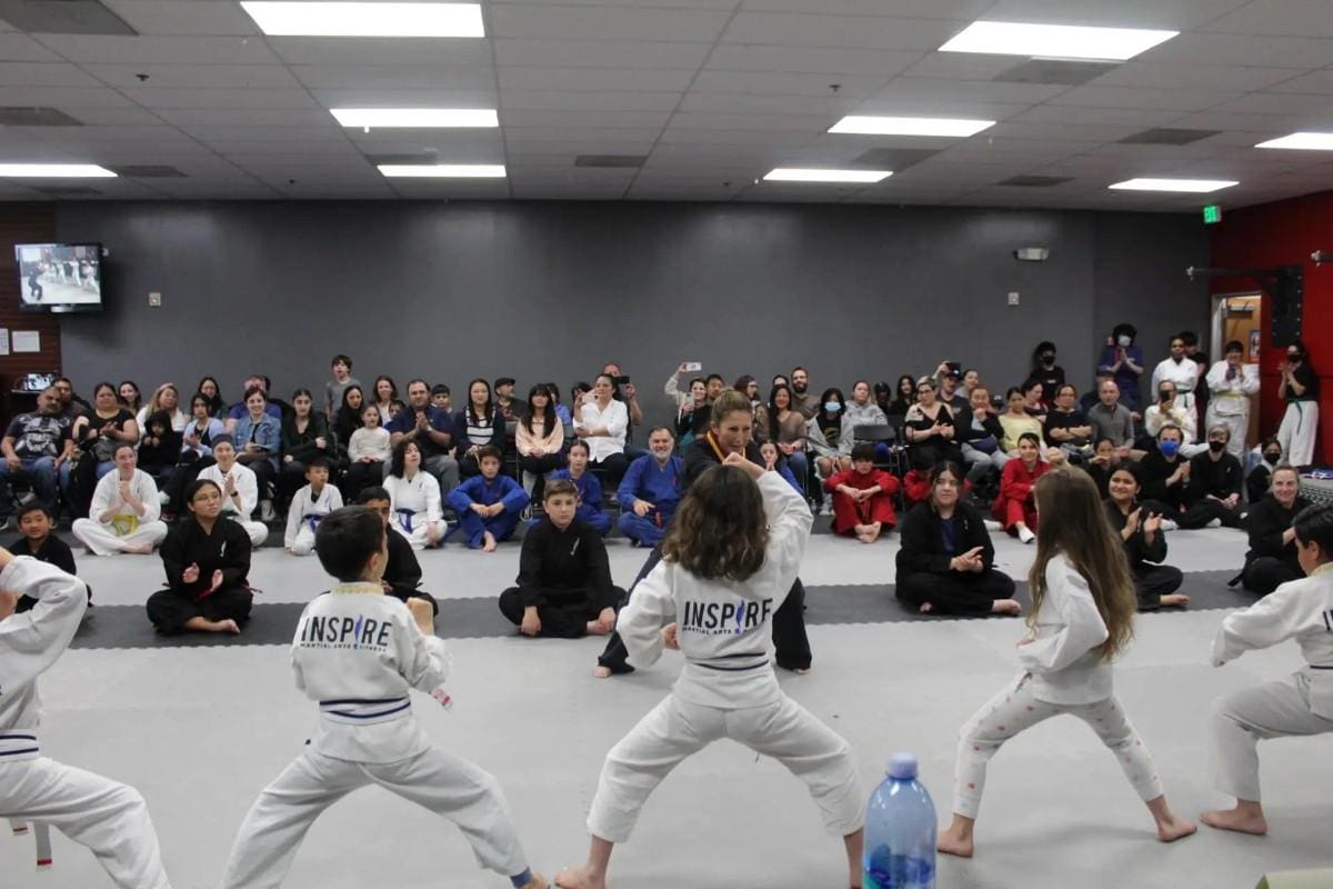 self defense students performing infront of many people in a studio